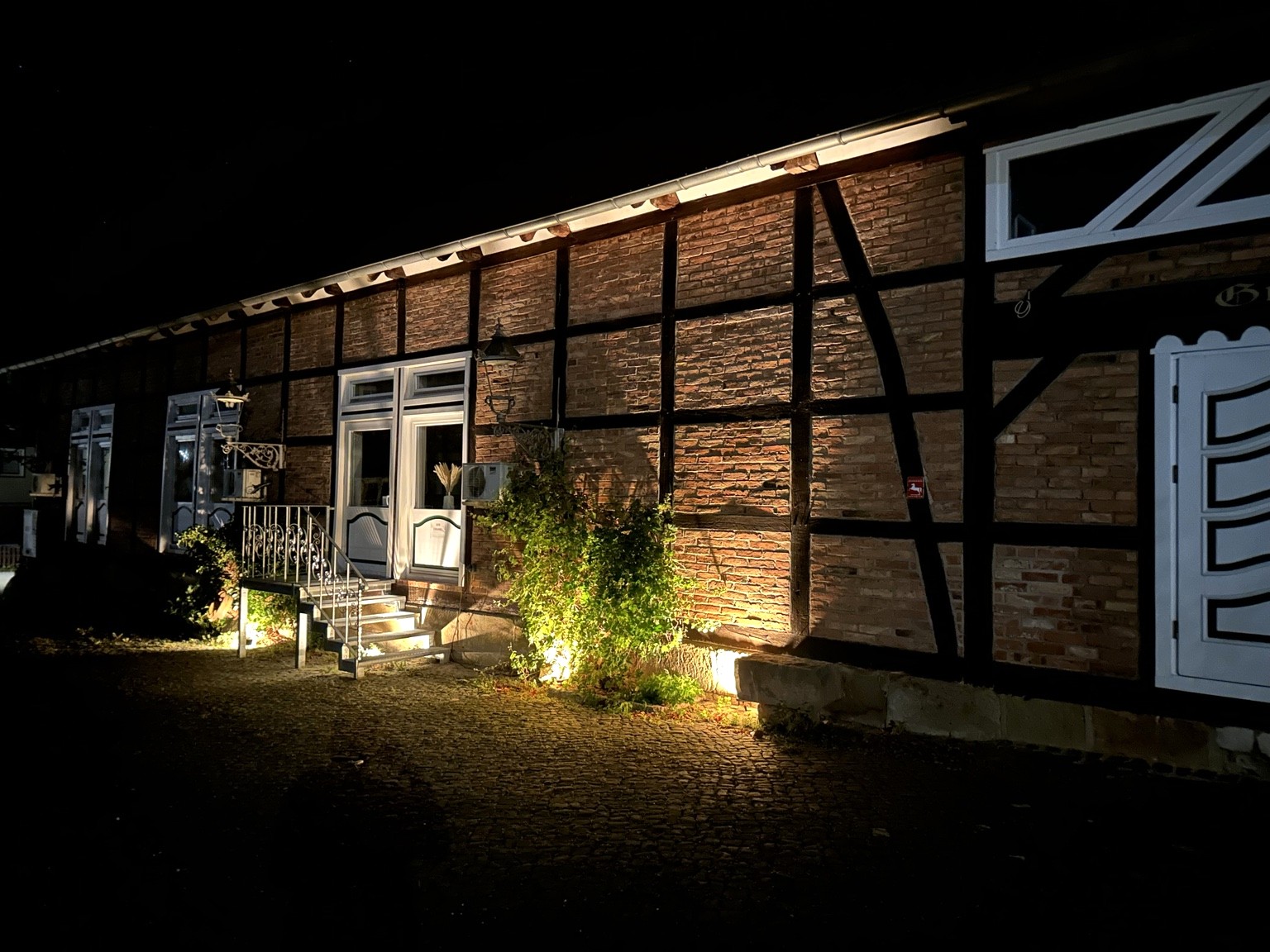Beleuchtetes Fachwerkgebäude des Gutshof Steinlah bei Nacht