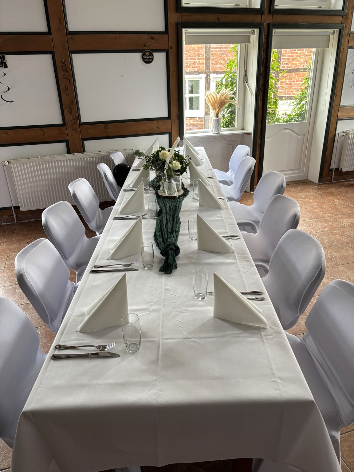 Festlich eingedeckte Tafel im Saal